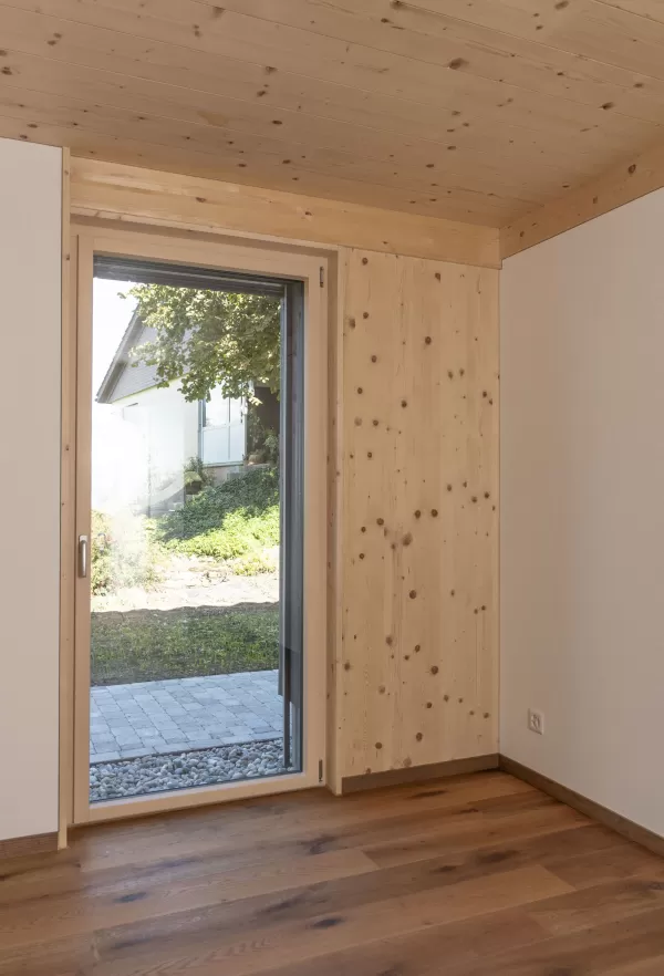 Mehrfamilienhaus Truberholzhaus Recherswil, Schweizer Holz, Truberholzwände sind nicht sichtbar, die Dübel sind nicht sichtbar, Fassade ist vorvergraut, es hat eine Attikawohnung, im Erdgeschoss und Obergeschoss hat es Loggaeinschnitte (Terrasse, Balkon), moderner Neubau, auf dem Dach ist ein Sonnensegel, Flachdach mit Solarpanel, es hat kein Keller dafür ein zusätzliches Gebäude mit Autounterstand und Lagerraum, Umschwung mit Rasen