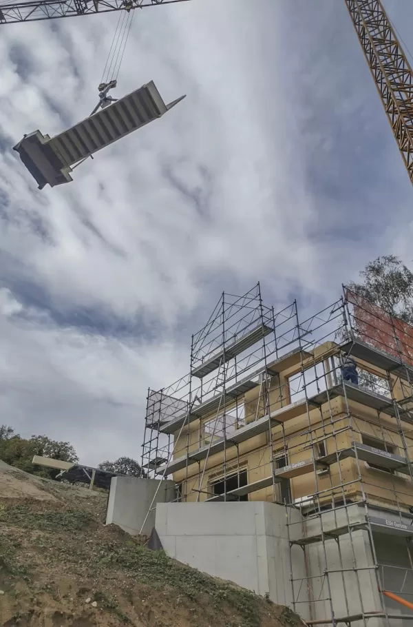 Einfamilienhaus Aufrichten in Münchenwiler bei schönstem Sonnenschein. Die Treppe wurde mit dem Baukran in das Haus gebracht. Die Elemente passen perfekt ineinander. Sehr gute Arbeit von unseren Mitarbeitern.