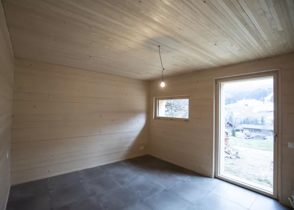 Ausbau Scheune zu Wohnhaus alles aus Truberholzelmente in Lauenen Berner Oberland. Freistehendes Cheminée zur ganzen Wohnungsheizung. Sonnenschutz aus Holz.